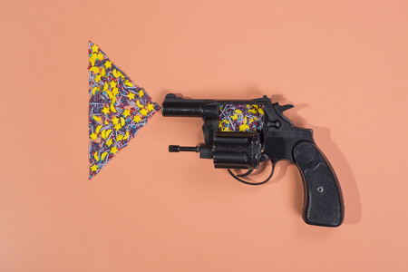 Revolver and Easter Confectionery powder on a beige background