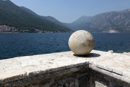 stone ball on the parapet of the ancient terrace on the background of the seaの写真素材