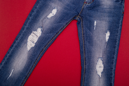 Ripped jeans light blue on a red backgroundの写真素材