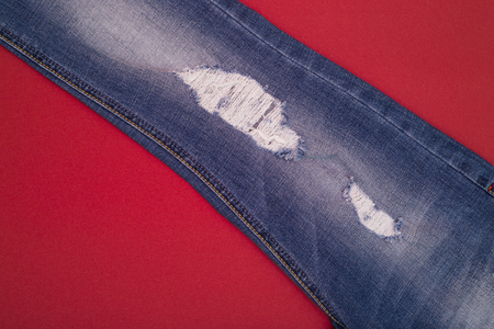 Ripped jeans light blue on a red backgroundの写真素材