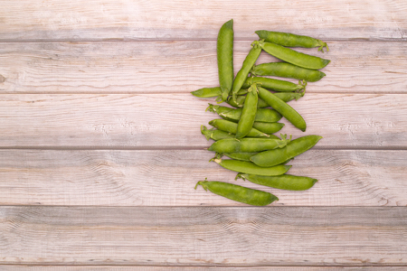 Green pea pods on a wooden backgroundの写真素材