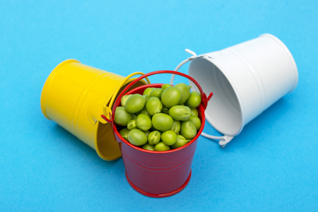 Still life with buckets and green peas on a blue backgroundの写真素材