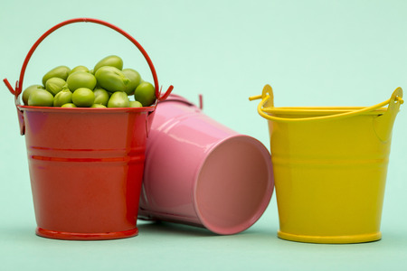 Still life with buckets and green peas on a green backgroundの写真素材
