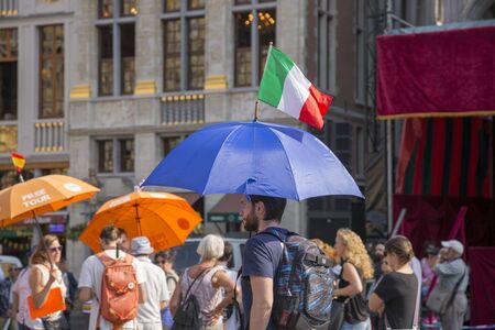 Brussels, Belgium - July 04, 2018: Tourist from Italy with a flag and an umbrellaのeditorial素材