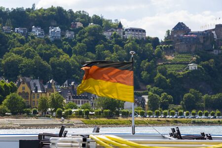 National flag of Germany at the stern of the ship on the background of the Rhine Riverのeditorial素材