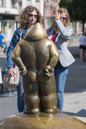 Wroclaw, Poland - July 09, 2018: Girls view the bronze Papa Dwarf on a pedestal in the center of Wroclaw, Poland. Back view.のeditorial素材