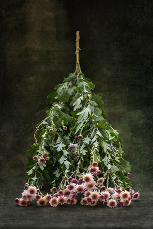 Still life with an inverted branch of flowers that looks like a Christmas tree.の写真素材