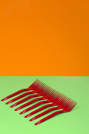 Abstract still life with red forks on a colored background