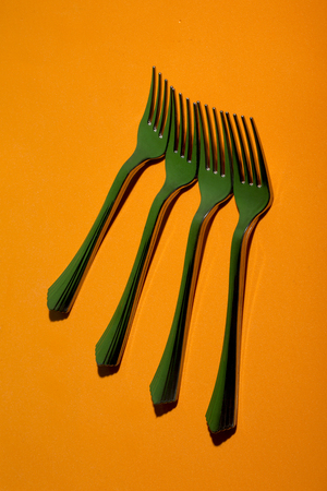 Abstract still life with forks on orange background