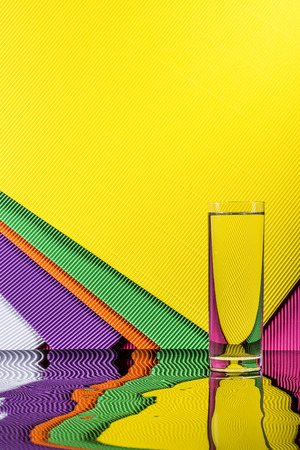Abstract still life with a glass of water on a color bright backgroundの写真素材
