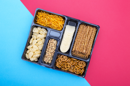 Box with a set of snack on a colored background, top viewの写真素材