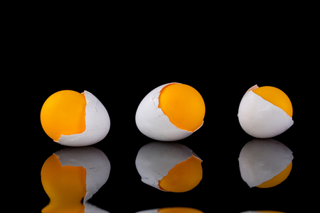 Egg shell with orange ball on a black background