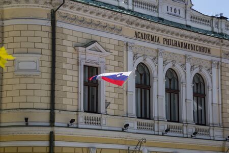 Ljubljana, Slovenia - August 15, 2019: Facade of the Slovenian Philharmonic Hall building on Congress Square in Ljubljana with the flag of Sloveniaのeditorial素材