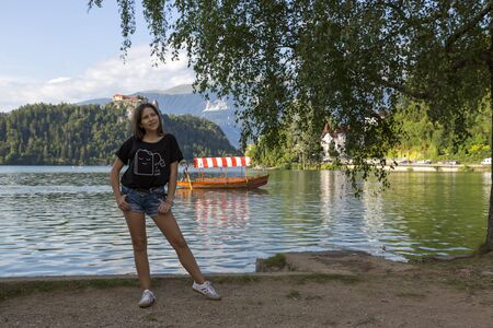 Smiling girl posing for a photograph on the shore of Lake Bled in Sloveniaのeditorial素材