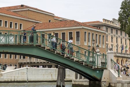 Venice, Italy - August 22, 2019: People go down the bridge over the canal in Venice.のeditorial素材