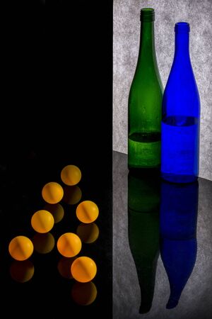 Still life with colored bottles and orange ballsの写真素材