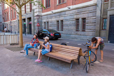Amsterdam, Netherlands - July 02, 2018: People rest on a bench in the center of Amsterdamのeditorial素材