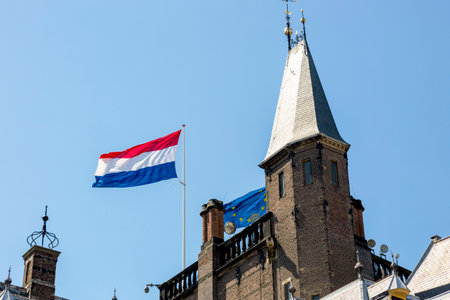 Flags of the Netherlands and the European Union on the roof of a building against the sky