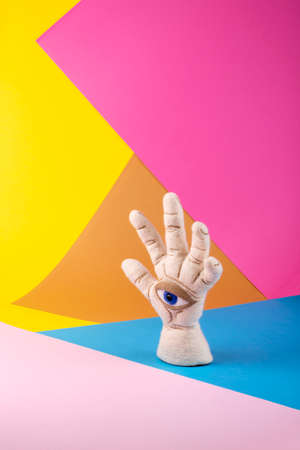 Protective amulet in the shape of an open palm and eye made of felted vul on a colored backgroundの写真素材