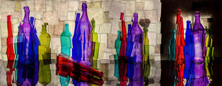 Abstract collage with colored bottles on a reflective surfaceの写真素材