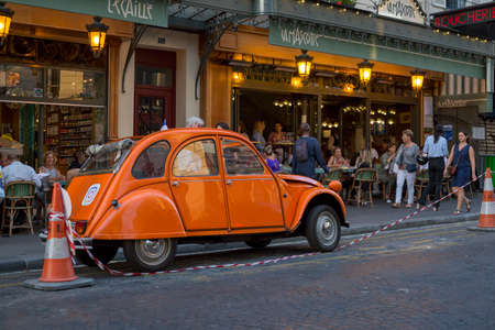 Paris, France - July 05, 2018: Vintage French car near a street cafe in Montmartre in Paris