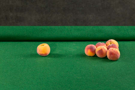 Figure of ripe peaches on a billiard table