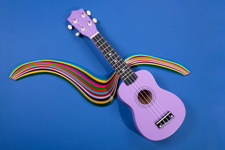 Four string ukulele guitar with a figure from colored paper