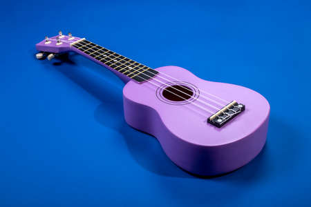 Four string ukulele guitar on blue backgroundの写真素材