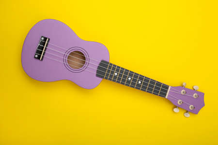 Four string ukulele guitar yellow backgroundの写真素材