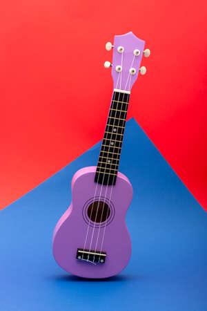 Four string ukulele guitar on red and blue backgroundの写真素材