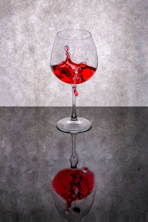 Still life with splashed red wine in a glassの写真素材