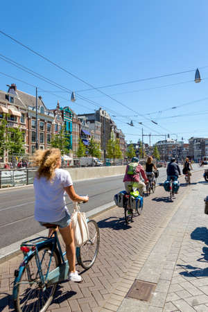 Amsterdam, Netherlands - July 02, 2018: People ride bicycles down the street in Amsterdamのeditorial素材