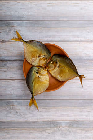 Three smoked sea fish Selene close-up in a plateの写真素材