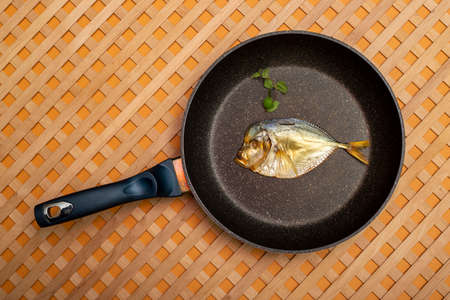 Smoked sea fish Selene close-up in a frying pan