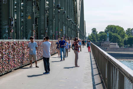 Cologne, Germany - July 07, 2018: People walk along the pedestrian part of the Hohenzollern Bridge in Cologneのeditorial素材