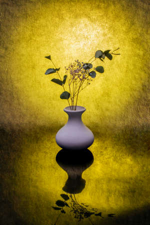Still life with wildflowers in a light vase on a yellow backdrop