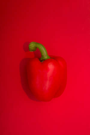 Red ripe bell peppers on a red background