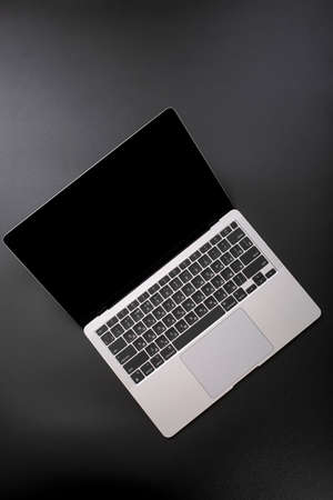 Open gray laptop on a dark background, top view