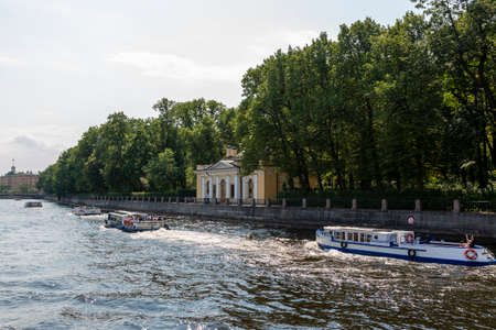 St. Petersburg, Russia - July 09, 2021: Several walking boat with people swims along the river Fontanka on the background of a Coffee House in the Summer garden in St. Petersburg.のeditorial素材