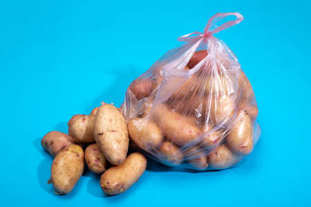 Fresh potatoes in a package on a blue backgroundの写真素材