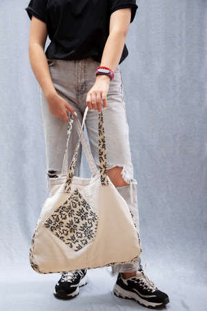 A girl holds in her hands a reusable Eco Bag made of natural fabrics