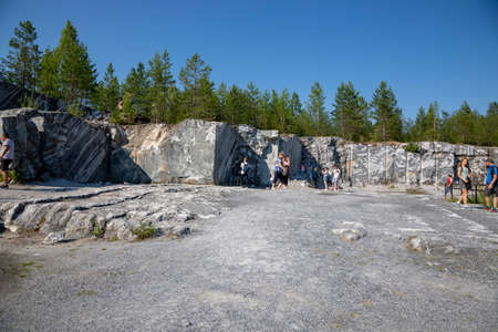 Ruskeala, Russia - July 10, 2021: People inspect the marble mining site in the Marble Canyon in...