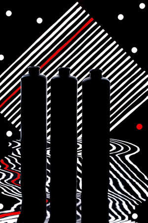 Still life with three bottles on a striped background with reflectionの写真素材