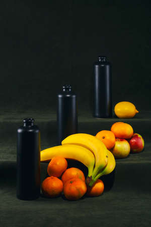 Still life with black bottles and fruits