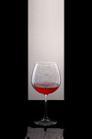 Still life with a glass of red wine on a black and white backgroundの写真素材