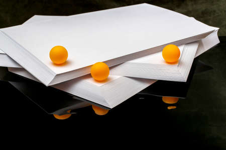 Still life with orange balls on sheets of white paper