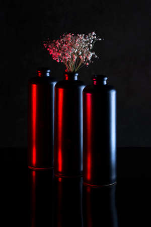Still life with a bouquet of flowers and three black vasesの写真素材