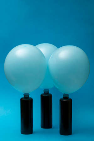 Balloons put on dark bottles on a blue background