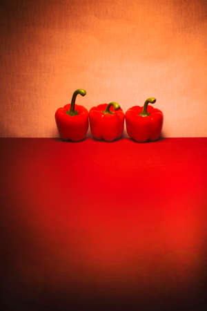 Still life with red peppers on the red table