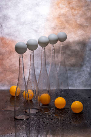 Still life with transparent figures, white and orange balls